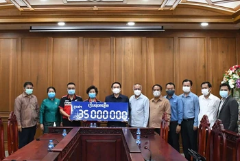 Bí thư, Tỉnh trưởng tỉnh Champasak Vilayvong Butdakham (thứ 5 từ trái qua) nhận ủng hộ của Hội người Việt Nam tỉnh Champasak. (Nguồn: Tổng Lãnh sự quán Pakse)