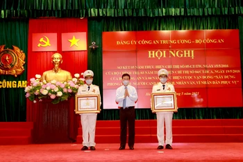 Đồng chí Võ Văn Thưởng, Ủy viên Bộ Chính trị, Thường trực Ban Bí thư trao Huân chương Quân công hạng Ba tặng đồng chí Lê Quốc Hùng và đồng chí Lê Tấn Tới.