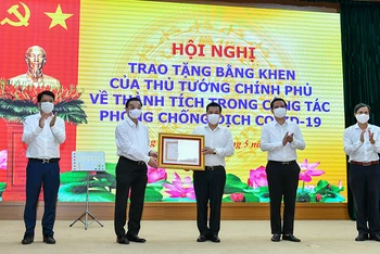 Chủ tịch UBND thành phố Chu Ngọc Anh trao Bằng khen của Thủ tướng Chính phủ cho nhân dân và cán bộ huyện Đông Anh. Ảnh: Duy Linh