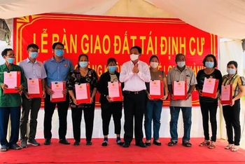 Phó Chủ tịch UBND tỉnh Đồng Nai Võ Tân Đức trao quyết định bàn giao đất và giấy chứng nhận quyền sử dụng đất cho các hộ dân.