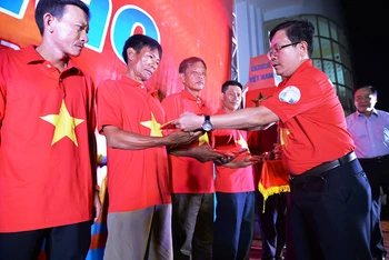 Đồng chí Tô Đình Tuân, Tổng Biên tập Báo Người Lao Động trao cờ cho ngư dân.