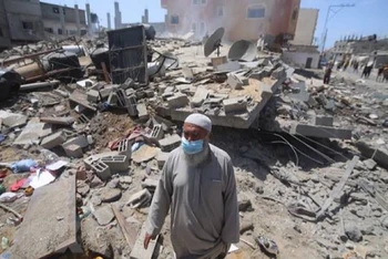 Người dân Palestine trở về bên những căn nhà đã bị phá hủy trong các cuộc không kích của máy bay Israel xuống thành phố Rafah, Dải Gaza, khi lệnh ngừng bắn được công bố. (Ảnh: THX/TTXVN)