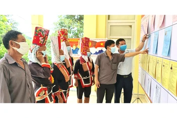 Người dân thôn Ngàn Vàng trên, xã Đồng Tâm, huyện Bình Liêu nghiên cứu tiểu sử các đại biểu được niêm yết tại khu vực bỏ phiếu