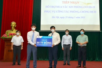 Bộ trưởng Y  tế Nguyễn Thanh Long tiếp nhận ủng hộ kinh phí mua vaccine phòng, chống Covid-19 từ Tổng Giám đốc Tập đoàn Hòa Phát Nguyễn Việt Thắng.