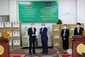 Đại sứ Vũ Quang Minh bàn giao hàng viện trợ cho Bộ trưởng Y tế Campuchia Mam Bunheng.