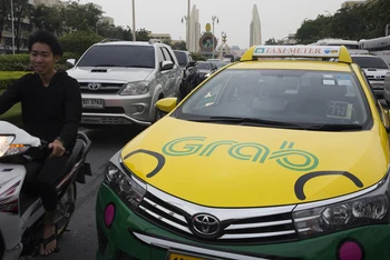 Một chiếc xe taxi dán biểu tượng ứng dụng gọi xe trực tuyến Grab lưu thông tại Thái Lan (Ảnh Bloomberg)