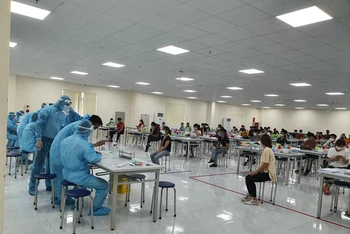 Lực lượng y tế lấy mẫu xét nghiệm Covid-19 cho công nhân tại KCN Vân Trung. (Ảnh: ĐẶNG GIANG)