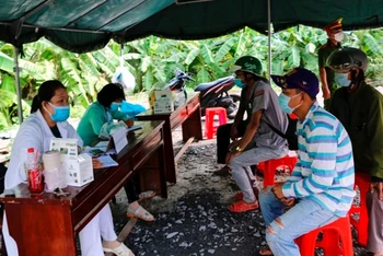 Người dân khai báo y tế tại một chốt kiểm soát dịch trên địa bàn huyện Tháp Mười.