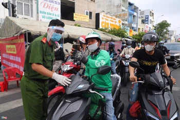 Người dân đi qua chốt Phan Văn Trị - Phạm Văn Đồng khai báo y tế nhanh.