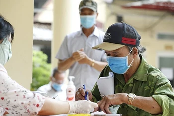 Chi trả tiền hỗ trợ dịch Covid-19 cho các đối tượng người có công và bảo trợ xã hội ở quận Đống Đa, Hà Nội. (Ảnh: DUY LINH).
