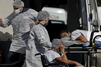 Nhân viên y tế chuyển bệnh nhân Covid-19 tới bệnh viện tại thủ đô Brasilia, Brazil. (Ảnh: AP)