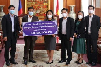 Đồng chí Thongsavanh Vongsamphan (trái) trao món quà giá trị 100 triệu kíp Lào tặng tỉnh Hải Dương, chiều 14-6.