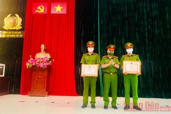 Lãnh đạo Công an quận Tây Hồ trao bằng khen của Chủ tịch UBND TP Hà Nội tặng hai chiến sĩ Công an kịp thời cứu người.