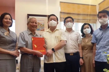 Đồng chí Nguyễn Trọng Nghĩa thăm và tặng hoa nhà báo lão thành Hà Đăng.