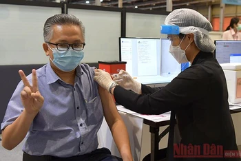 Một người dân Bangkok tiêm vaccine ngừa Covid-19 tại điểm tiêm chủng ở trung tâm thương mại Ladprao. (Ảnh: NAM ĐÔNG)