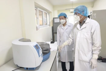Thứ trưởng Nguyễn Trường Sơn kiểm tra hệ thống xét nghiệm tại Viện Pasteur TP Hồ Chí Minh. (Ảnh: KHÔI NGUYỄN)