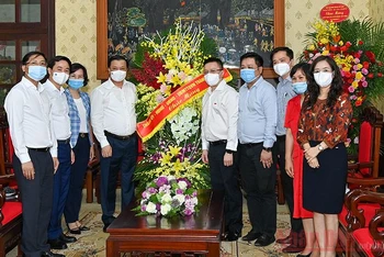 Đồng chí Đinh Tiến Dũng, Ủy viên Bộ Chính trị, Bí thư Thành ủy Hà Nội cùng các đồng chí lãnh đạo thành phố tặng hoa chúc mừng Báo Nhân Dân. Ảnh: Duy Linh