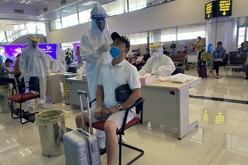 Cán bộ lấy mẫu xét nghiệm nhanh Covid-19 cho hành khách tại sân bay Nội Bài. (Ảnh: Sở Y tế Hà Nội)