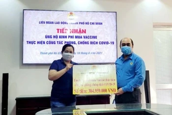 Công đoàn Đại học Quốc gia TP Hồ Chí Minh trao bảng biểu trưng kinh phí mua vaccine Covid-19 cho Liên đoàn Lao động TP Hồ Chí Minh.