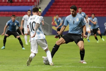 Messi với pha đi bóng vượt qua tiền đạo Luis Suarez (Uruguay). 