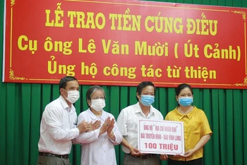 Đại diện gia đình cụ Lê Văn Mười trao tiền cúng điếu tới các tổ chức, cá nhân làm công tác an sinh xã hội trên địa bàn tỉnh Vĩnh Long.