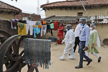 Nhân viên y tế tới làng Sikanderpur, quận Chandauli, bang Uttar Pradesh để lấy mẫu xét nghiệm Covid-19 và vận động người dân tiêm phòng. (Ảnh: AP)