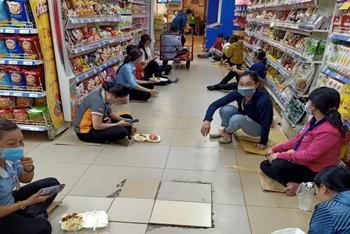Hình ảnh các nhân viên đang cách ly tại một cửa hàng thực phẩm tại quận 1, TP Hồ Chí Minh trong thời gian chờ kết quả xét nghiệm.