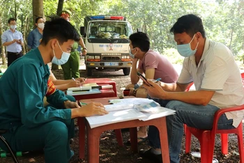 Lực lượng chức năng lập biên bản xử lý các đối tượng thâm nhập vào Bình Phước mà không khai báo y tế theo quy định. 