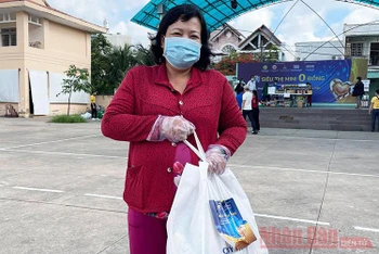 Cô Nghĩa, một lao động tự do tại địa phương, hồ hởi sau khi mua sắm.