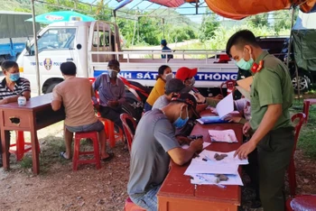 Lực lượng công an hướng dẫn người dân khai báo y tế ở chốt kiểm dịch xã Canh Hòa, huyện Vân Canh, tỉnh Bình Định.