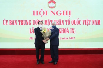 Đồng chí Đỗ Văn Chiến tặng hoa chúc mừng đồng chí Lê Tiến Châu (bên trái).
