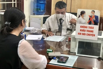 Cán bộ tư pháp hộ tịch phường Vĩnh Tuy, quận Hai Bà Trưng thực hiện ký chứng thực và đóng dấu hồ sơ theo quy định mới.