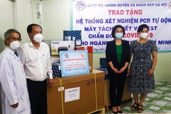 Giám đốc Sở Y tế Hà Nội Trần Thị Nhị Hà trao tặng ngành Y tế TP Hồ Chí Minh hệ thống xét nghiệm PCR tự động, máy tách chiết và test chẩn đoán Covid-19. 