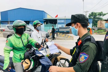 Lực lượng chức năng tỉnh Đồng Nai kiểm tra giấy xét nghiệm của người dân trên Quốc lộ 1K, đoạn giáp ranh giữa Đồng Nai với Bình Dương.