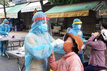 Ngành chức năng lấy mẫu test nhanh cho tiểu thương và người dân đi chợ phường 2, thành phố Tân An, Long An. 