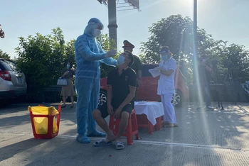 Lực lượng y tế tiến hành lấy mẫu test nhanh tại chỗ với lái xe từ tỉnh Hà Nam đi vào Hà Nội.