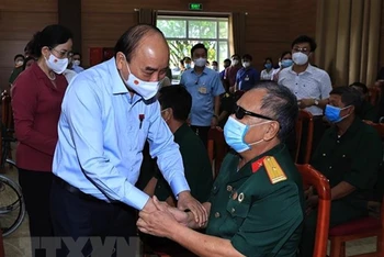 Chủ tịch nước Nguyễn Xuân Phúc đến thăm hỏi, tặng quà các thương bệnh binh tại Trung tâm Nuôi dưỡng thương bệnh binh nặng và điều dưỡng người có công tỉnh Hà Nam. (Ảnh: TTXVN)