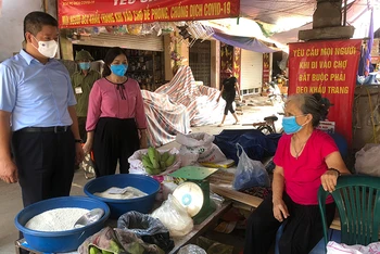 Phó Chủ tịch UBND TP Hà Nội Nguyễn Mạnh Quyền nhắc tiểu thương tại Chợ trung tâm thị trấn Chúc Sơn tuân thủ các yêu cầu phòng chống dịch Covid-19.