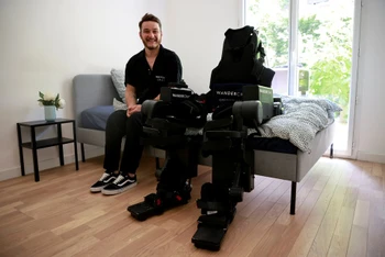 Anh Kevin Piette bên cạnh khung xương do công ty Wandercraft của Pháp chế tạo nhằm giúp đỡ những người bị liệt đi lại được. (Ảnh: Reuters).