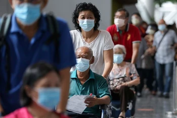 Người dân chờ tiêm vaccine ngừa Covid-19 tại trung tâm tiêm chủng ở Kuala Lumpur, Malaysia. (Ảnh: Reuters)