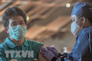 Nhân viên y tế tiêm vaccine phòng Covid-19 cho người dân tại Jakarta, Indonesia, ngày 23/7/2021. (Ảnh: THX/TTXVN)