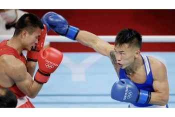 Văn Đương (áo đỏ) gặp khó trước Erdenebatyn - từng giành HCV ở Đại hội Thể thao châu Á 2018 và HCĐ ở Giải Vô địch Boxing thế giới năm 2015, 2017. (Ảnh: Reuters)