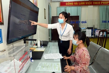 Hướng dẫn người dân thực hiện dịch vụ công trực tuyến tại phường Trung Hòa, quận Cầu Giấy, Hà Nội (ảnh chụp trước ngày TP Hà Nội thực hiện giãn cách xã hội). (Ảnh: DUY LINH)