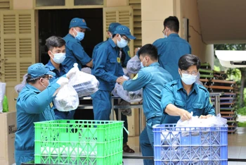 Lực lượng dân quân tự vệ TP Hồ Chí Minh chuẩn bị các suất cơm để phát cho công dân trong khu cách ly y tế tập trung.