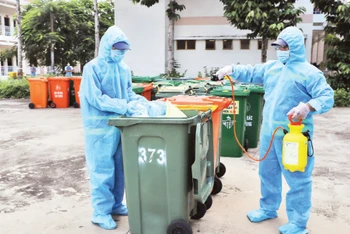 Công nhân Công ty Môi trường đô thị tiến hành khử khuẩn rác thải y tế liên quan dịch Covid-19.