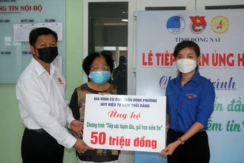 Bà Cao Thị Chắt trao bảng tượng trưng số tiền 50 triệu đồng cho đại diện Tỉnh đoàn Đồng Nai.