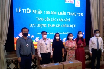 Đại diện Công ty Pacific Food và Công ty VinaFirst trao tặng 100.000 khẩu trang y tế cao cấp.