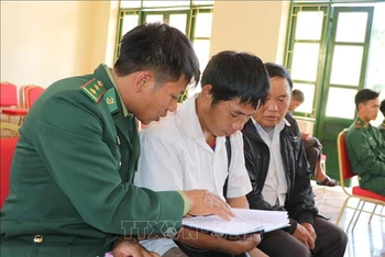 Chiến sĩ Đồn biên phòng Nậm Kè (Bộ đội Biên phòng tỉnh Điện Biên) trao đổi nội dung tuyên truyền, phổ biến pháp luật cho các trưởng bản. Ảnh: TTXVN.