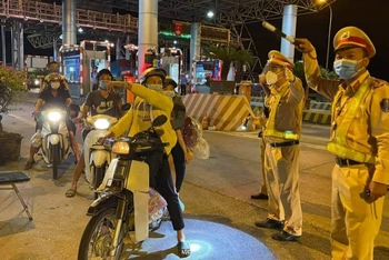Lực lượng Công an hướng dẫn tận tình cho người dân đi xe máy từ tâm dịch về quê.