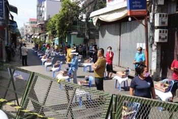 Khoảng 100 gia đình tại quận Russey Keo, Phnom Penh bị phong tỏa vì liên quan đến ca nhiễm SARS-CoV-2 được nhận quà cứu trợ. (Ảnh: Fresh News)